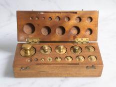 A mahogany case of graduated brass weights