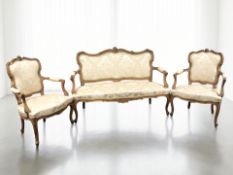 A French carved walnut three piece salon suite, circa 1920's, comprising settee, length 145 cm,