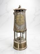 An Eccles steel and brass miner's safety lamp.