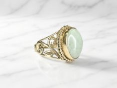 A 9ct gold cabochon jade ring, in pierced setting to a plain shank,