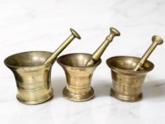 Three 18th / 19th century bronze bell mortars with pestles, tallest mortar 12 cm.