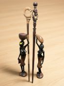 Two carved African figures and two walking staffs