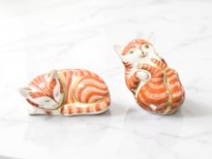 Two Royal Crown Derby recumbent cat paperweights, with gold stoppers.