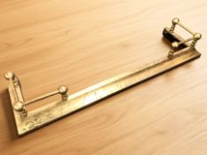 A Victorian brass extending fire curb,