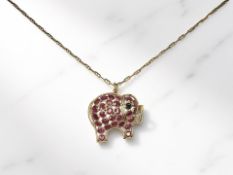 A ruby and sapphire elephant pendant on chain, the pendant 2.5cm wide, both stamped '750' or '18K'.