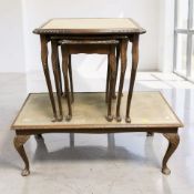 A reproduction carved beech nest of three tables with leather inset panels,
