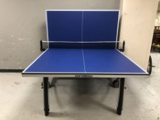 A folding table tennis table with net, bats and balls, overall 275 cm x 153 cm x 77 cm.