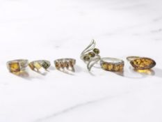 Six silver and silver-gilt dress rings set with amber