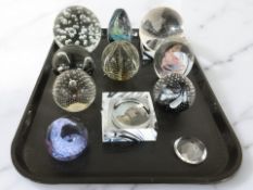 Eleven studio glass paperweights.