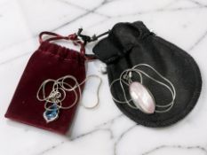 A silver blue stone pendant on chain and a further mother of pearl pendant on chain.