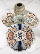 A group of oriental wares including a Japanese Imari charger, diameter 32 cm, two smaller plates,