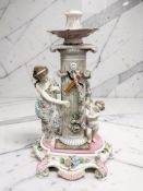 A 19th century Meissen candlestick surmounted by cherub and female figure, height 36 cm.