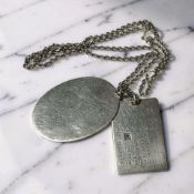 A hallmarked silver dog tag style necklace with calendar, and a further blank oval pendant on chain.