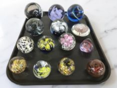 Fourteen studio glass paperweights.