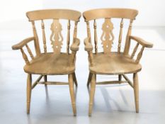 A pair of reproduction pine farmhouse spindleback armchairs, width 57 cm.