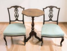 A pair of Victorian carved mahogany salon armchairs and an octagonal tripod table.