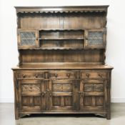 A reproduction carved oak and leaded glass dresser, 169 cm x 44 cm x 197 cm.