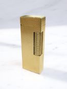 A Dunhill gold-plated rollagas lighter with engine-turned case, height 6.5cm.