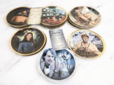 A group of collector's plates including John Wayne and Star Trek.