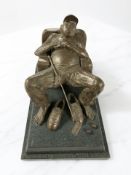 A reproduction bronze figure of a reclining golfer on plinth, length 27 cm.