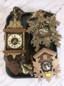 Two reproduction Black Forest-style cuckoo clocks and a further continental wall clock.