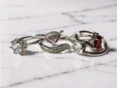 Four silver dress rings set with white and coloured stones including one in the form of a fox.