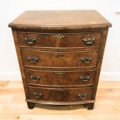 A 1920's figured walnut bow front four drawer chest in the Georgian style, 59 cm x 43 cm x 77 cm.