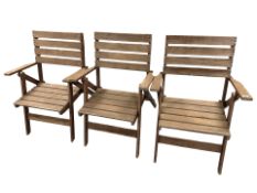 Three stained teak folding garden chairs.