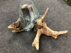 A large decorative glass vase housed in a rustic rootwood surround, width 80 cm.