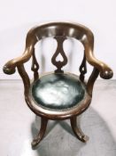 An early 20th century walnut elbow chair with studded leather seat, width 65 cm.