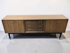 A 20th century G-Plan teak and ebonised low sideboard designed by E Gomme, 191 cm x 44 cm x 77 cm.