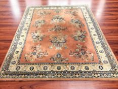 A machined Chinese woolen carpet on salmon ground, 305 cm x 243 cm.