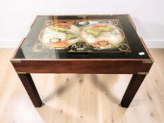 A chess board coffee table with removable plate glass top depicting a map of the world,