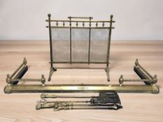 A Victorian brass spark guard, a fire curb and companion pieces.
