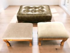 A buttoned leather footstool on pad feet, width 60 cm, and a further pair of smaller stools.