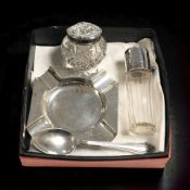 A silver ash tray, a teaspoon and two silver topped dressing table bottles.
