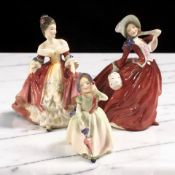 Three Royal Doulton figures 'Autumn Breezes' HN1934, 'Southern Belle' HN2229, and 'Babie' HN1679.