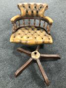 A tan leather Chesterfield swivel captain's chair.