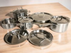 A group of Le Creuset stainless steel cooking pans.