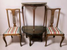 An oak drop leaf coffee table, a demilune table and a pair of chairs.