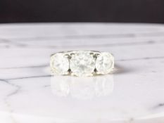 An 18ct white gold dress ring set with three synthetic stones,