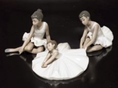 Three Nao figures of seated ballerinas.