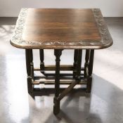 A carved oak gateleg drop leaf table, extended 104 cm wide.