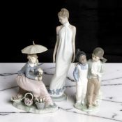 A Nao figure of a lady holding a parasol, and two further Nao figures.