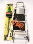 A Ryobi electric hedge trimmer and two stepladders.