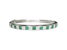 A fine 18ct white gold emerald and diamond bangle,