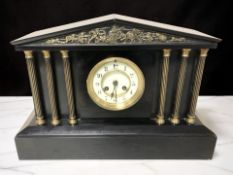 A Victorian black slate eight day mantel clock with enameled dial, height 30 cm.