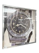 A colour print of a Rolex Submariner, 49 cm x 49 cm.