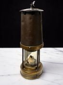 An antique Patterson, Gateshead, steel and brass miner's safety lamp.