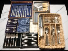 Several cases of EPNS cutlery and a further wicker tray containing loose cutlery.